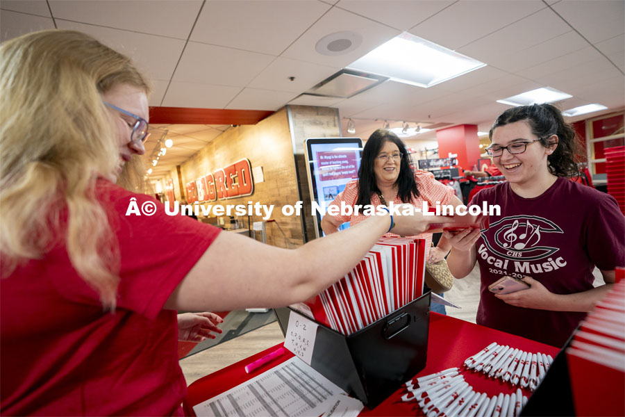 Taryn Wiegand (right) of Columbus, Nebraska, smiles as she receives her information folder during Red Letter Day check-in inside the Nebraska Union. September 13, 2024. Photo by Jordan Opp for University Communication.